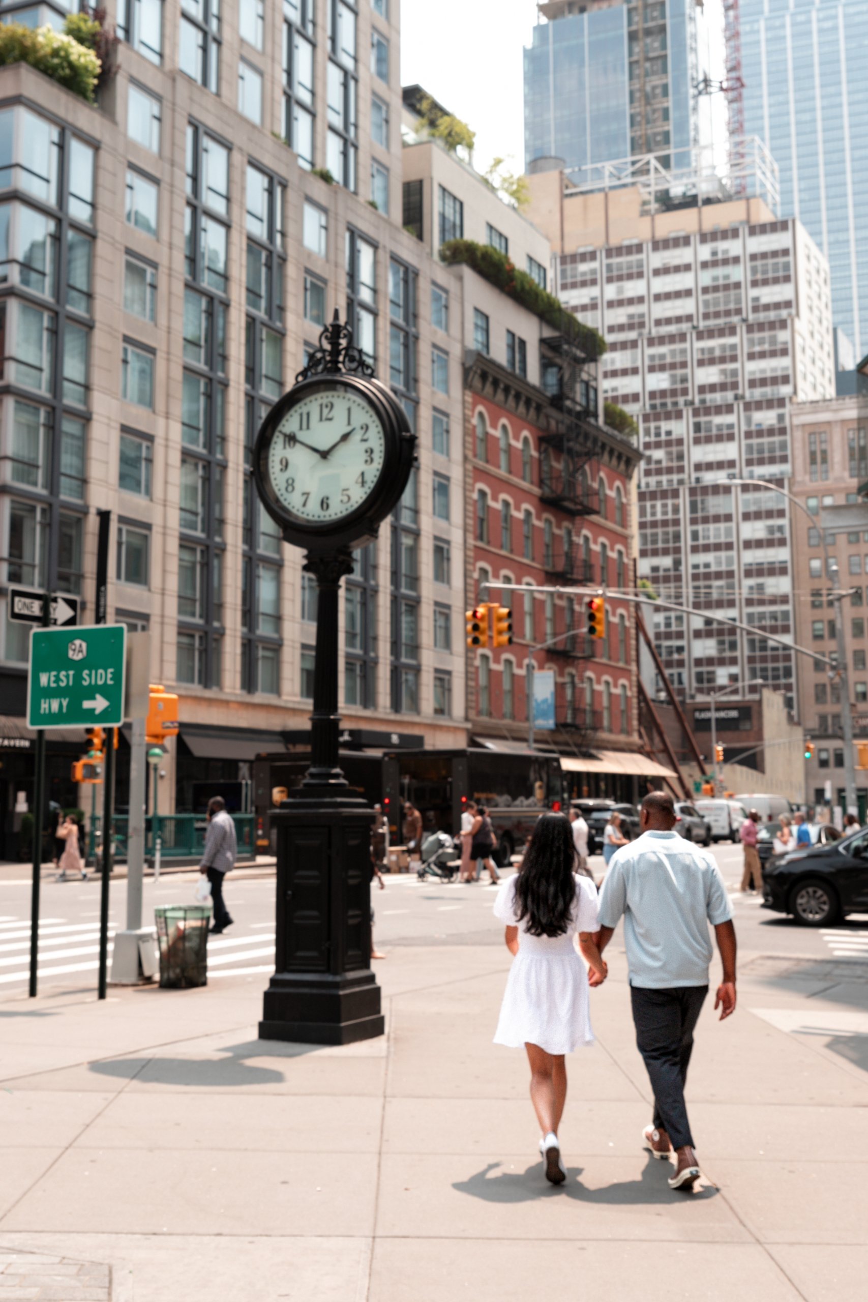 A couple strolling down a Tribeca in NY, hand in hand, enjoying each other's company and the urban scenery.